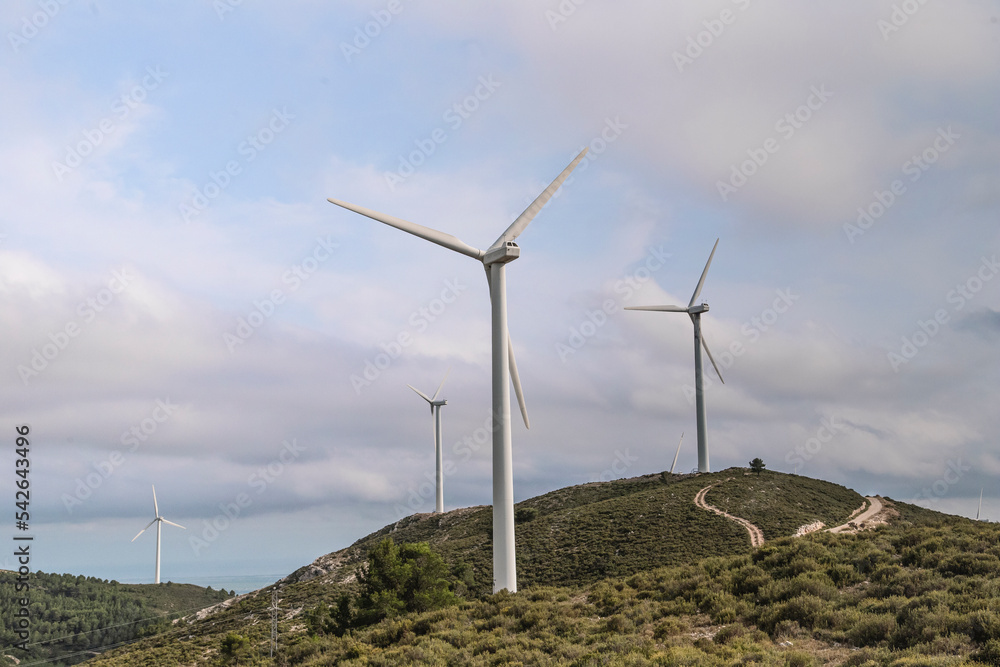 Roads Leading Towards Windmills Against Cloudy Sky Roads Leading Towards Windmills Against Cloudy Sky