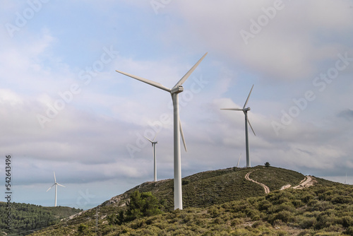 Roads Leading Towards Windmills Against Cloudy Sky