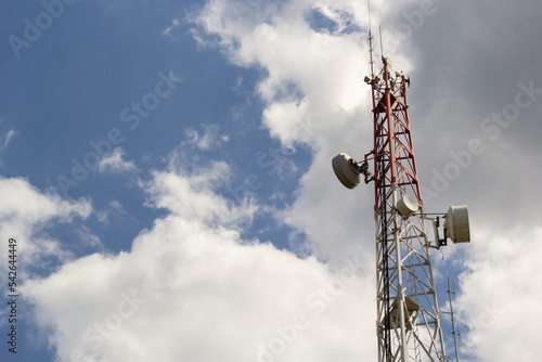 Telecommunication tower for mobile phone with antennas over a blue sky. Distribution function of contract mobile phones
