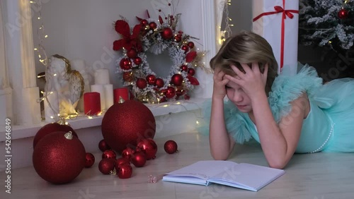 A teenage girl can't figure out what to write in a letter to Santa Claus. The child is nervous. A girl in a smart dress writes a letter to Santa Claus