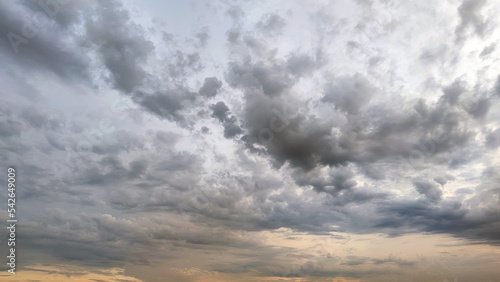 Cloudy sky with stormy clouds. Low cumulus clouds of various shapes cover almost the entire sky. They are at different heights and have different colors of white, light gray and dark blue.