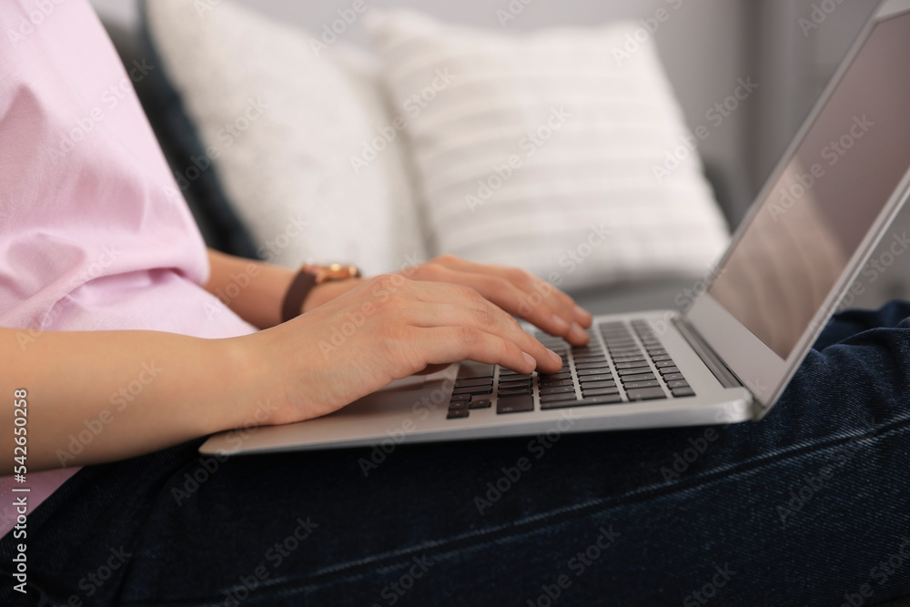Woman with laptop on sofa at home, closeup Woman with laptop on sofa at home, closeup