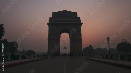 This enchanting timelapse captures the breathtaking spectacle of sunrise at India Gate, a historic monument in the heart of Delhi. As the city awakens, the tranquil beauty of dawn unfolds, painting th photo