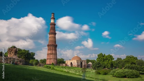 Time-lapse of moving clouds over the qutub minar amidst the garden during the day in Delhi, India. photo