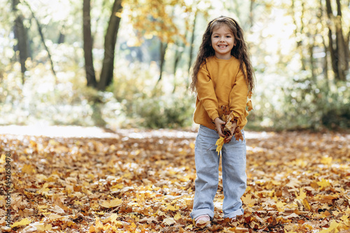 Cute little girl walking in autumnal park