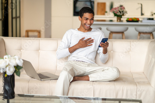 Free Download Young black man with a smartphone in hands looking happy - GFXLoad