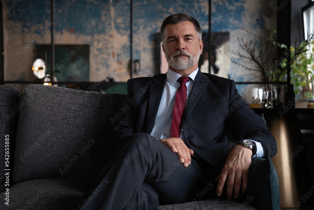 Starting new working day. Mature businessman sitting on the couch in office. Starting new working day. Mature businessman sitting on the couch in office.