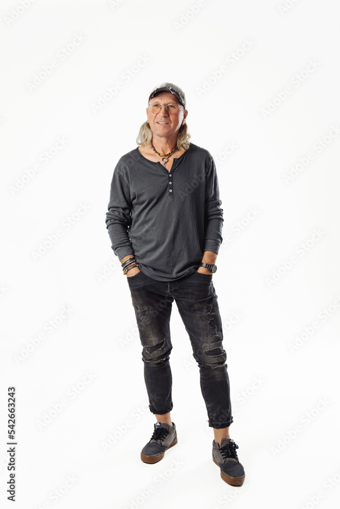 Shot of smiling mature European man dressed in casual grey jumper looks directly at camera . Full height. Shot of smiling mature European man dressed in casual grey jumper looks directly at camera . Full height.