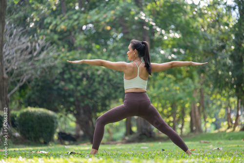 Asian slim woman exercise alone in the park, Tired from a workout, Play yoga concept 