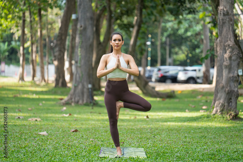 Asian slim woman exercise alone in the park, Tired from a workout, Play yoga concept 
