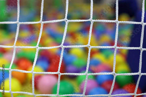 children's center - multi-colored balloons and a toy out of focus behind the grid