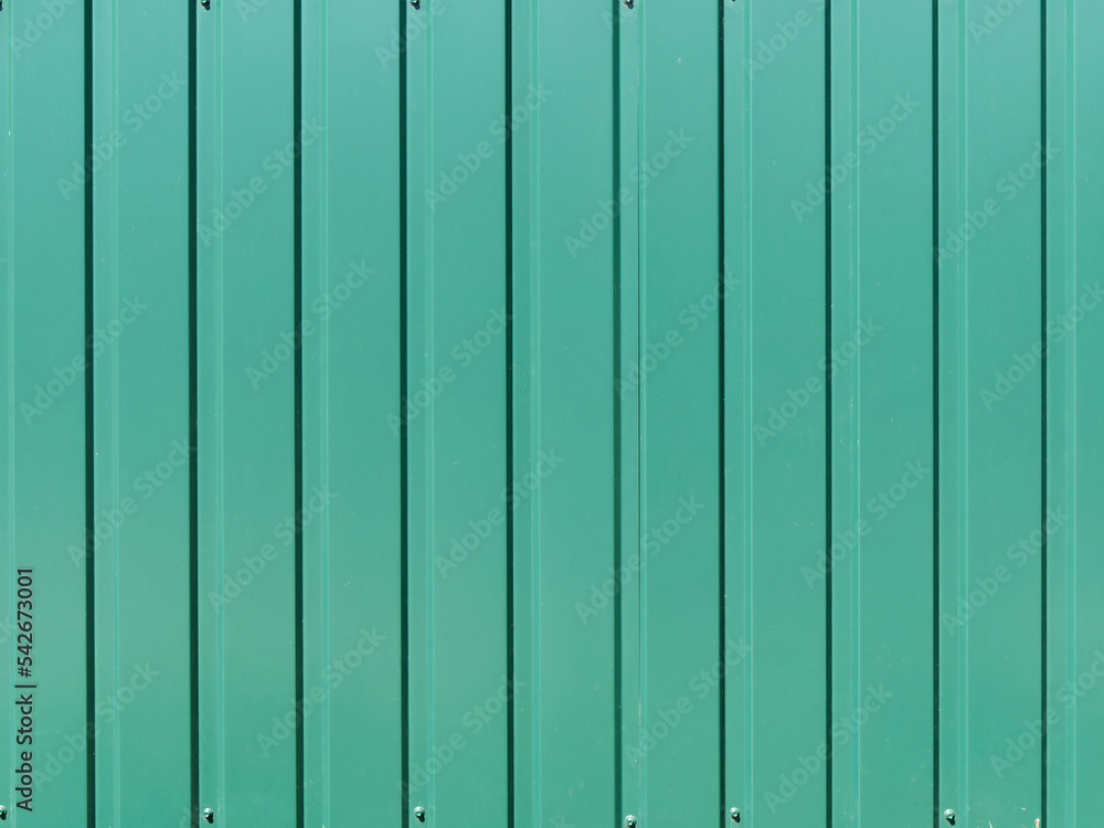Background of a fence made of vertical green metal strips Background of a fence made of vertical green metal strips