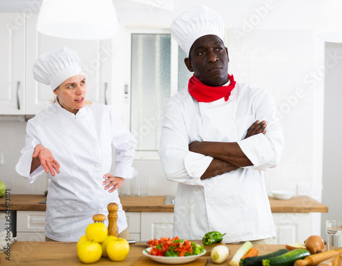 фотографія Chefs in white uniform having conflict on kitchen