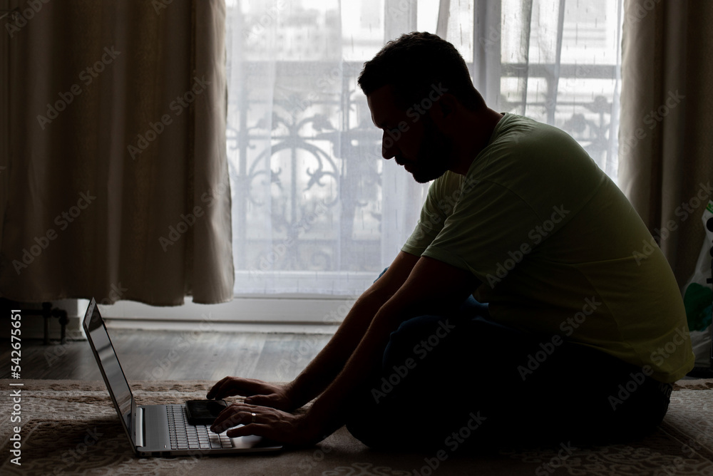 a man working at home on a laptop a man working at home on a laptop