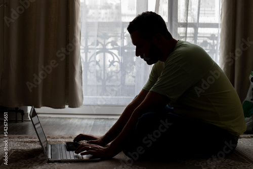 a man working at home on a laptop © Міша Мула