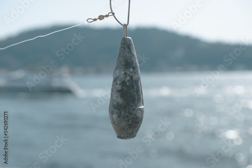 Obraz na plátně Fishing lead with blurred Bosphorus, angling concept banner, close-up fishing eq