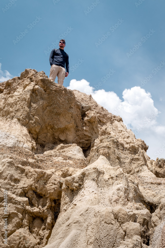 Young adult man standing at the top the cliff at Valle de la Luna (Moon valley), La Paz, Bolivia