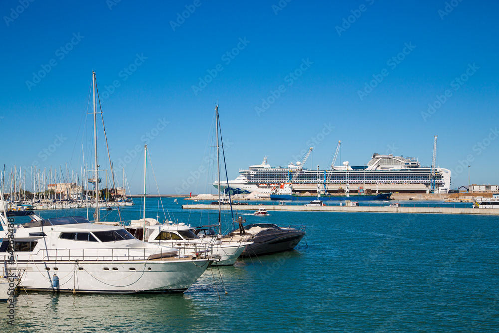Marina bay with yachts, vessels, sailboats and other ships in Livorno, Italy. Sunny day with blue sky and sea water
