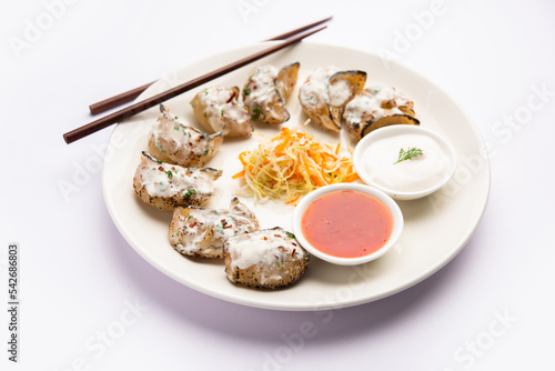 Tandoori momo, veg or non veg in red and cream sauce, served with sauce.  Nepal and Tibet recipe photo