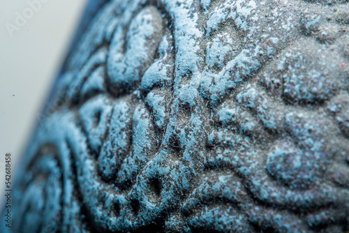 Close-up of the surface of an old homemade jug. The wall of a handmade vessel painted with paint in soft focus at high magnification.