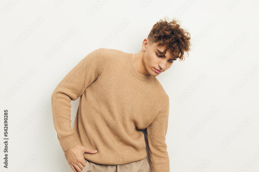 horizontal photo of a cute, neutrally emotional man in a beige sweater looking towards an empty space horizontal photo of a cute, neutrally emotional man in a beige sweater looking towards an empty space