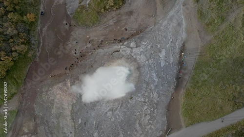 People around geyser erupting in Iceland. Aerial top-down directly above. Static view