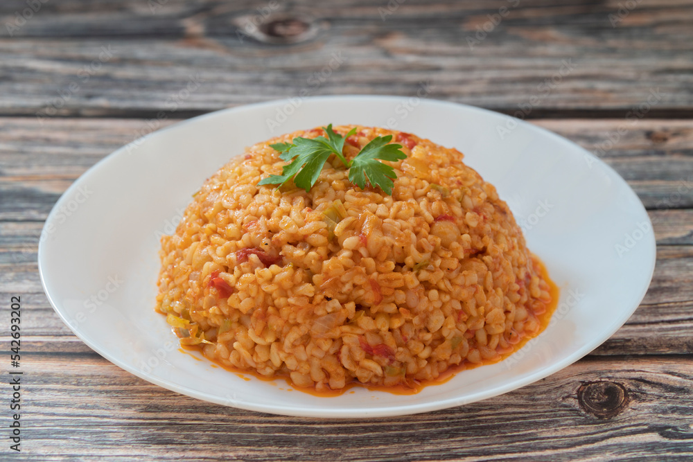 Traditional turkish bulgur pilaf with tomato sause in plate (Turkish name; meyhane pilavi) Traditional turkish bulgur pilaf with tomato sause in plate (Turkish name; meyhane pilavi)