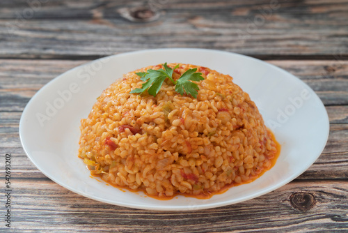 Traditional turkish bulgur pilaf with tomato sause in plate (Turkish name; meyhane pilavi) photo