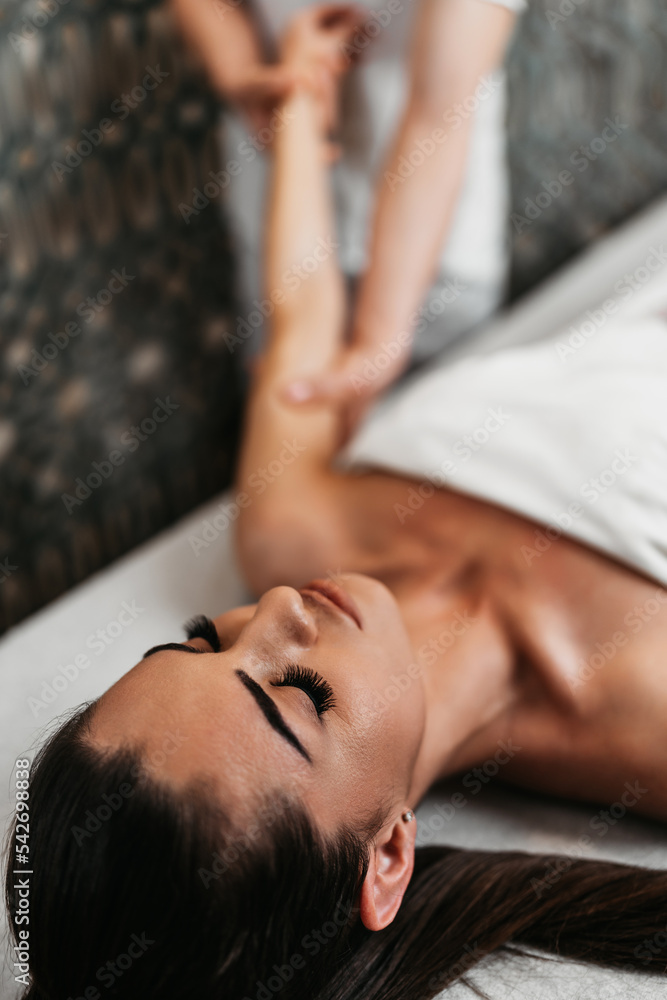 Fototapeta premium Beautiful young woman receiving professional body massage treatment with aromatherapy essential oil.