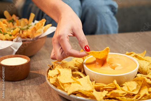 Фотография woman's hand spreading nachos on a cream
