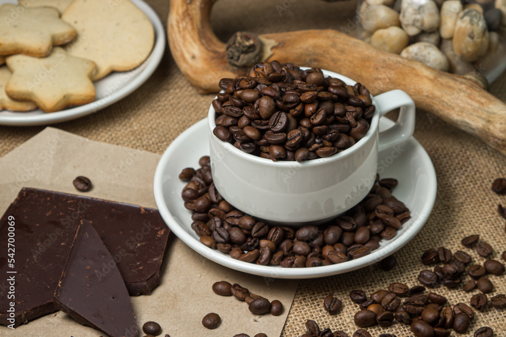 Coffee with chocolate. Cup full of coffee beans and chocolate pieces Coffee with chocolate. Cup full of coffee beans and chocolate pieces