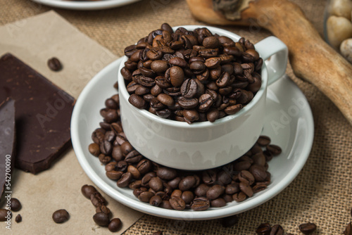 Coffee with chocolate. Cup full of coffee beans and chocolate pieces