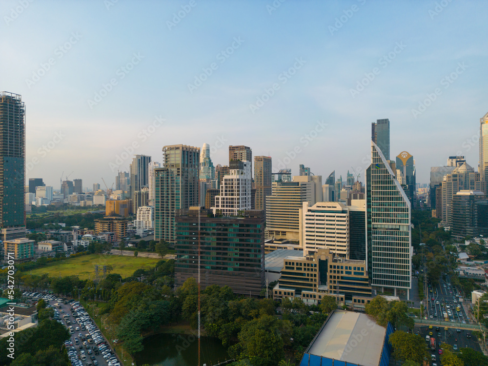 Obraz premium Aerial view modern office buildings and condominium park in Bangkok city downtown with sunset sky and clouds