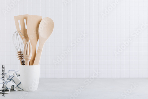 Kitchen utensils. Kitchen wooden tools and kitchenware. White modern kitchen interior background.