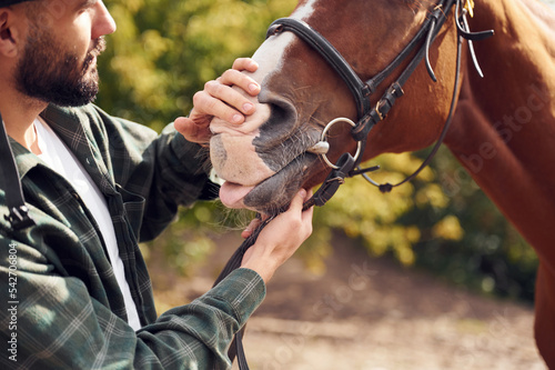 Young man with a horse is outdoors © standret