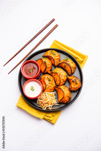 Tandoori momo, veg or non veg in red and cream sauce, served with sauce.  Nepal and Tibet recipe photo