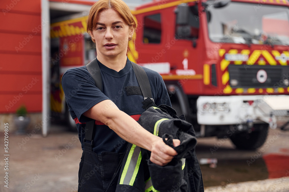 Taking off the protective clothes. Woman firefighter in uniform is at work in department Taking off the protective clothes. Woman firefighter in uniform is at work in department