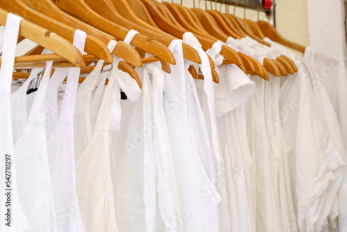 Organic eco clothes on a hanger. Home-made white clothing from natural and processed fabrics, natural vegetable ingredients. Eco-friendly dresses and shirts photo