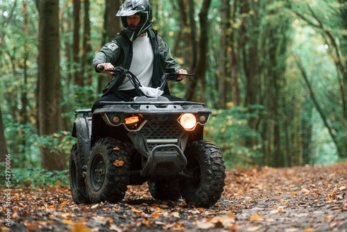 ATV driver is in the forest, having a ride at daytime