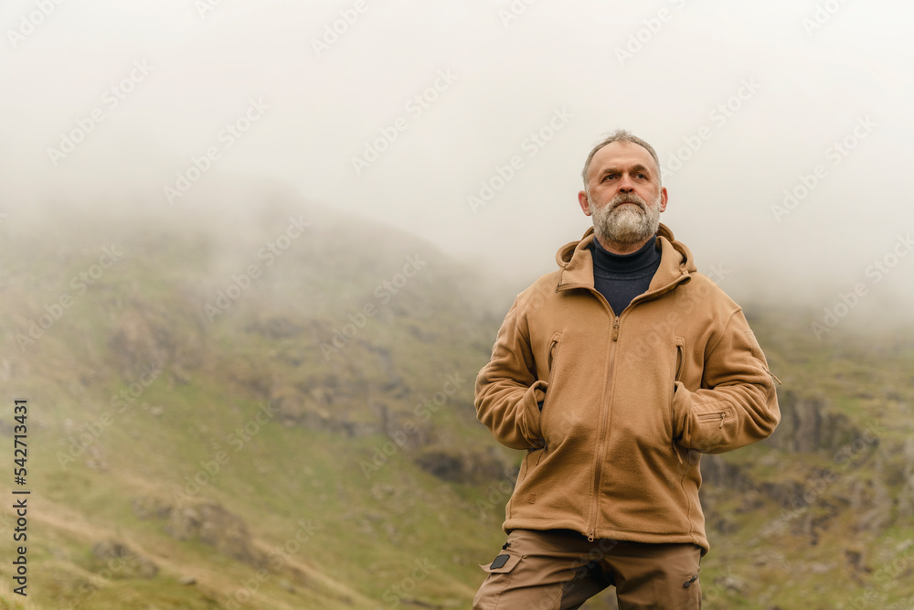 Bearded Man reaching the destination and on the top of mountain at sunset on autumn day Travel Lifestyle concept The national park Lake District in England