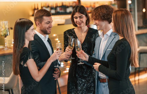 Conception of celebrating event. Group of people in elegant clothes are in the restaurant
