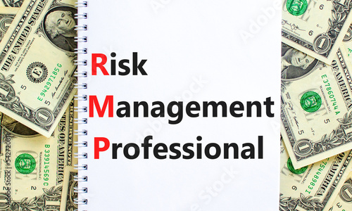 RMP risk management professional symbol. Concept words RMP risk management professional on white note on a background from dollar bills. Business RMP risk management professional concept. Copy space. photo