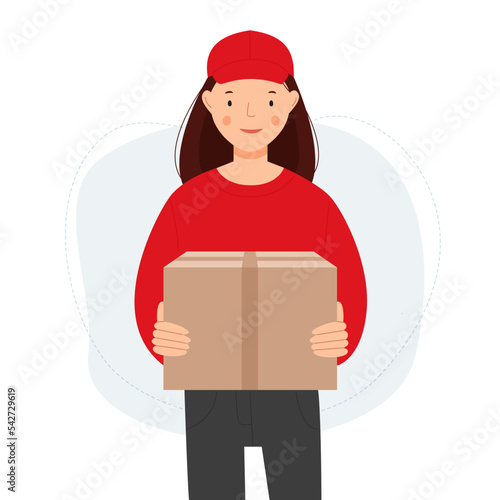 A female courier in a red uniform carries a cardboard box. The woman delivers a package. 