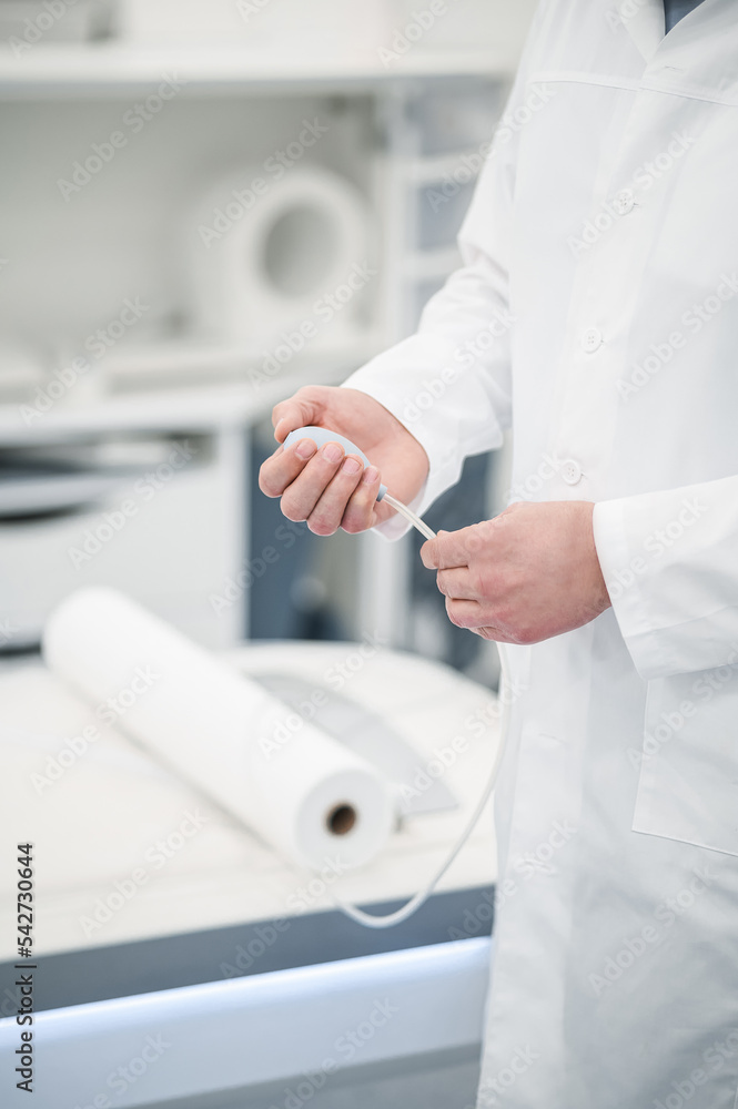 Male gray-haired doctor in a lab coat working in diagnostic center Male gray-haired doctor in a lab coat working in diagnostic center