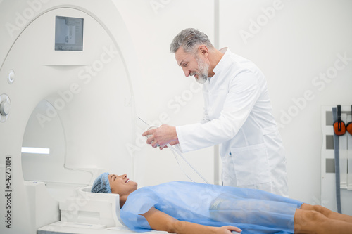 Male doagnostic specialist preparing the patient to MRI