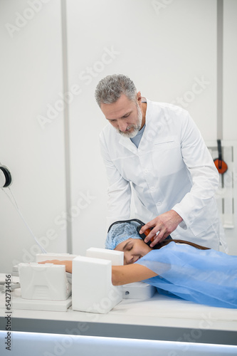Mature male doctor preparing a patient to MRI investigation