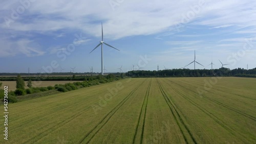 Wind turbines towers on electricity farm spinning and producing green energy
