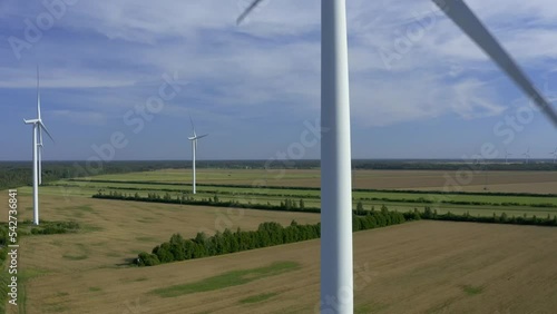 Wind turbines towers on electricity farm spinning and producing green energy