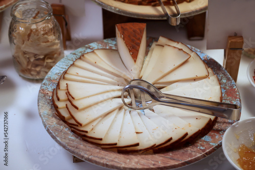 Ein Käse in der Form einer Torte mit vielen Scheiben Käse. photo