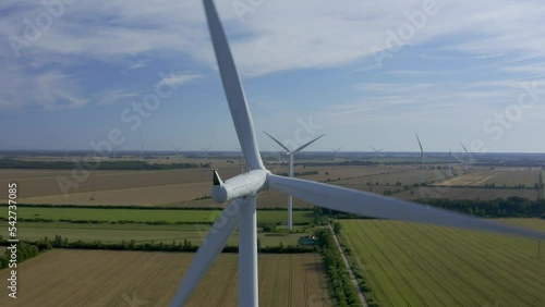 Wind turbines towers on electricity farm spinning and producing green energy